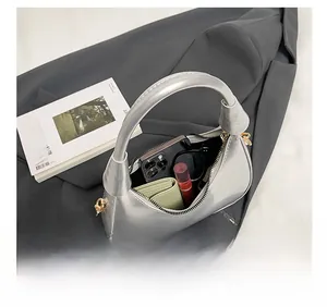 Top view of silver crescent bag showing capacity for phone, wallet, and lipstick