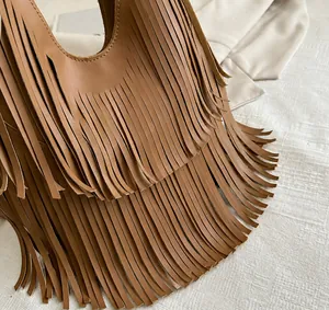 Macro view showing the high-quality brown leather fringe details of a fashion tote bag