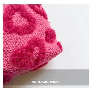 Close-up van de zachte roze gebreide pluche textuur en het verhoogde hartpatroon