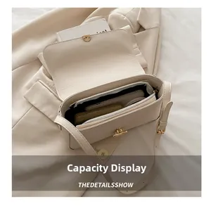 Interior view showing the large capacity and multiple compartments of the beige shoulder bag