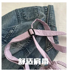 Detail of adjustable purple nylon shoulder strap with black buckle on denim background