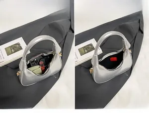 Silver crescent bag showing spacious interior with phone, wallet, and essentials