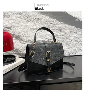 Détail d'un sac à main en cuir noir avec paillettes argentées et boucle dorée