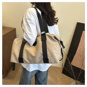Side view of large khaki oxford travel bag with adjustable black buckle on a person