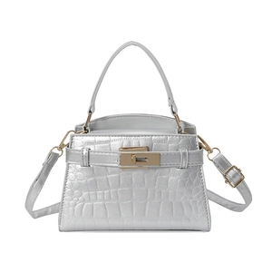 Silver crocodile embossed handbag with gold hardware and adjustable strap on white background