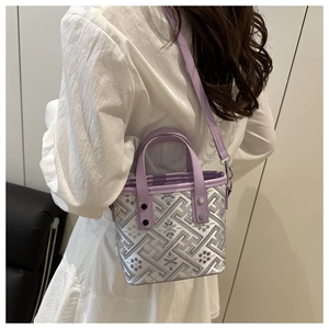 Detail of purple plaid woven pattern and leather texture on a bucket bag