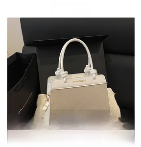 Detail of canvas and leather contrast handbag featuring a round handle and fashion bag logo