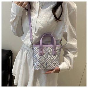 Detail of a purple geometric woven mini bucket bag with leather strap and metal rivets