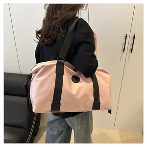 Pink oxford duffel bag worn by model, showing spacious side view and black woven straps