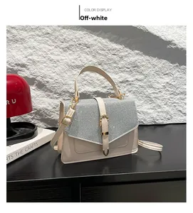 Détail du sac bandoulière blanc crème avec rabat à paillettes argentées et boucle dorée