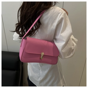 Rear view of model wearing pink faux leather underarm bag with gold buckle clasp detail