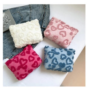 Close-up of soft plush heart pattern cosmetic pouches available in four pastel colors