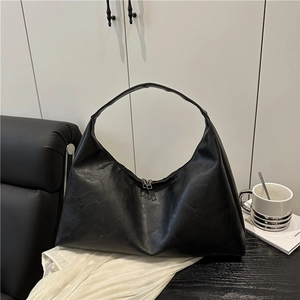 Minimalist black oversized hobo bag with a sleek crescent design and premium leather texture