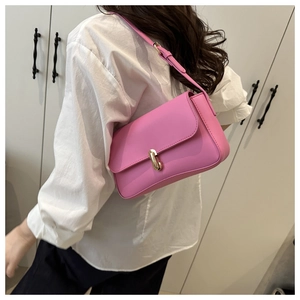Detailed back view of pink faux leather underarm bag with gold clasp on a shoulder