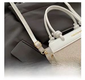 Close-up of adjustable strap and golden buckles on a stylish woven crossbody handbag