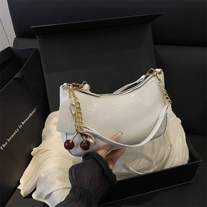 White glossy patent leather hobo bag with a red cherry charm and silver chain strap