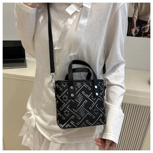 Detail view of black fabric bucket bag with silver geometric embroidery and silver rivets