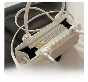 Close-up of white handbag opening with metal zipper and beige woven side texture