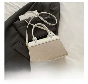 Detail showing the woven texture and cream leather strap of this stylish crossbody bag