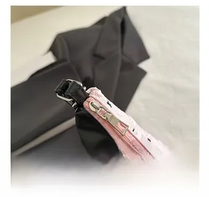 Gros plan d'une fermeture éclair argentée sur un sac à bandoulière rose à motifs