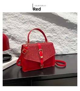 Détail du rabat pailleté rouge sur sac à main de luxe avec fermoir doré et poignée en cuir