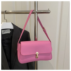 Detailed close-up of pink leather handbag with elegant gold metal lock and shoulder strap