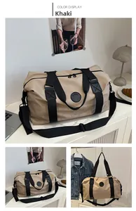 Detail view of khaki large travel duffel bag with black straps in home setting