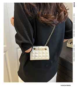 Détail du mini sac blanc matelassé avec chaîne dorée porté par un mannequin