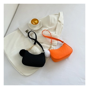 Detailed view of trendy casual women's shoulder bags with pom-pom and chain accents