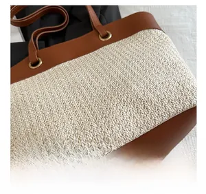 Detail of straw woven texture with premium brown leather trim and metal ring buckle