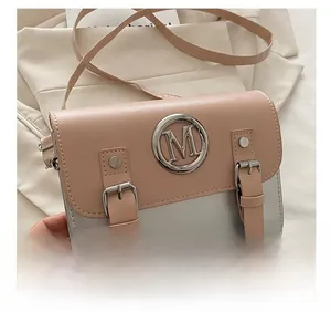 Close-up of pink and silver color-block crossbody bag with metal M logo and twin straps
