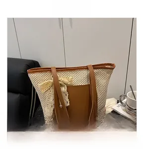 Detail of woven straw tote bag with brown leather handles and a delicate lace bow
