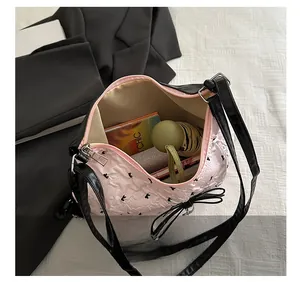 Intérieur du sac seau plissé rose montrant l'espace pour parapluie et carnet