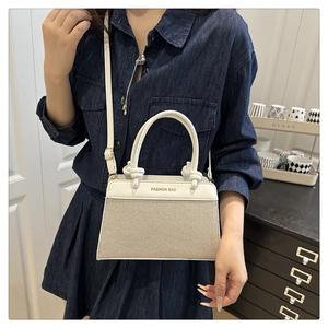 Detail of contrast linen shell bag with round handles and FASHION BAG print