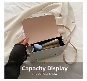 Detail view showing internal capacity of messenger bag with phone and cosmetics