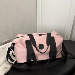 Light pink waterproof nylon pillow bag with black straps on a modern textured surface