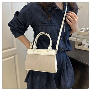 Detail of a contrast canvas and white leather shell bag featuring Fashion Bag print
