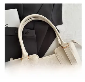 Detail of cream lychee leather handbag with light gold hardware and cylindrical handle