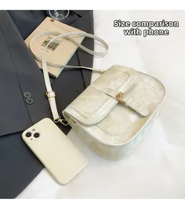 Cream textured saddle bag shown next to a smartphone to demonstrate daily storage capacity
