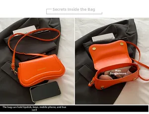 Detail view of orange leather bag showing interior capacity for cosmetics and phone