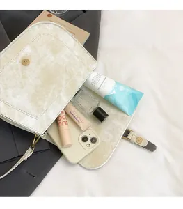 Macro shot of off-white retro crossbody bag interior with compartments for essentials