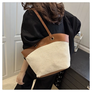 Detail of vintage woven tote bag with brown leather straps shown on model shoulder