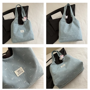 Detailed views of light blue denim tote bag with white bow prints and plush charm