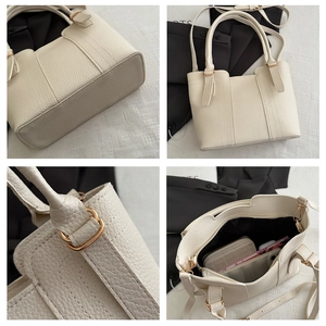 Detail of cream leather bucket bag with gold hardware and spacious interior storage