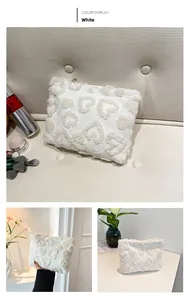 Detail showing the soft plush texture and raised heart pattern of the white bag