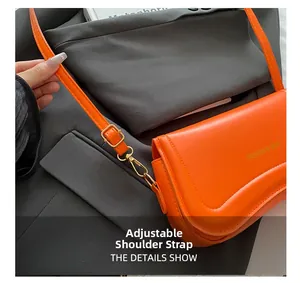 Detail of orange flap bag featuring golden fashion text and adjustable leather shoulder strap