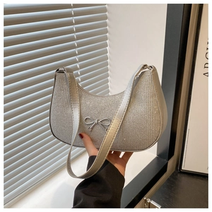 Detail of silver rhinestone crescent hobo bag with metallic bow and glitter finish
