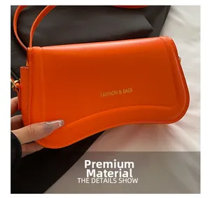 Close-up of bright orange faux leather bag showing premium texture and gold hardware