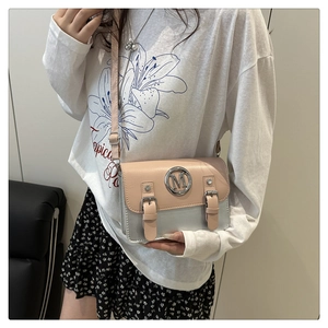 Détail du sac bandoulière rose et argenté avec logo M porté par le mannequin