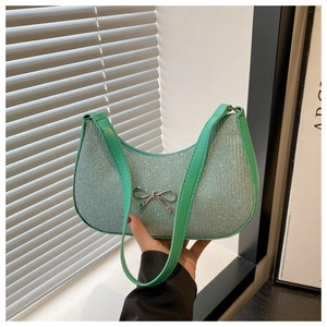 Close-up of mint green sequin crescent bag featuring a silver metal bow detail